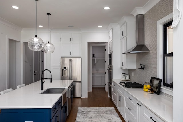 6821 Springwater St, Smyrna, TN 37167 - kitchen featuring ornamental molding, blue cabinets, wall chimney exhaust hood, and appliances with stainless steel finishes