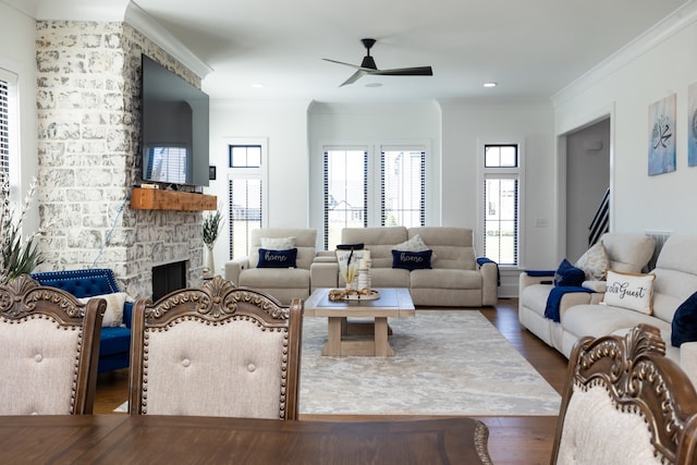 living room with ornamental molding, ceiling fan, a fireplace, and hardwood / wood-style floors