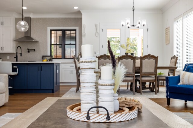 dining room featuring wood-type flooring, a notable chandelier, crown molding, and a wealth of natural light