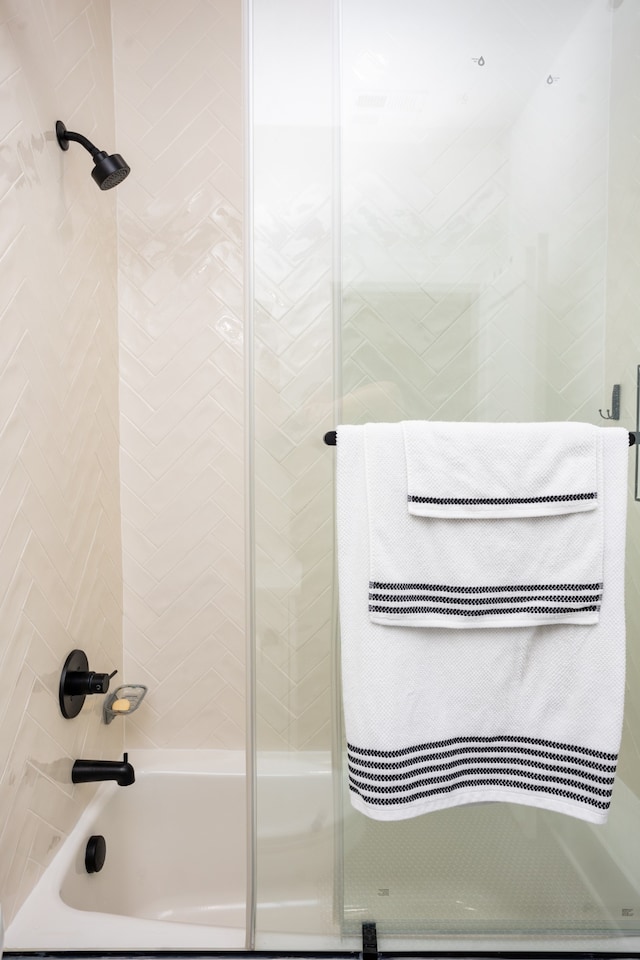 bathroom with combined bath / shower with glass door