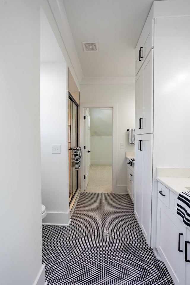 bathroom with walk in shower, vanity, and toilet