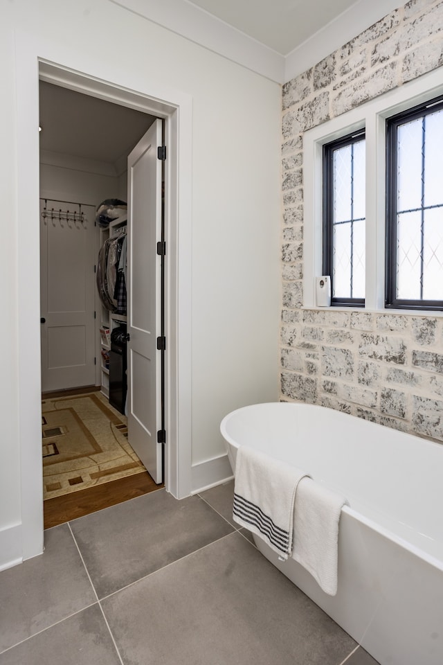 bathroom featuring hardwood / wood-style flooring, ornamental molding, and a tub