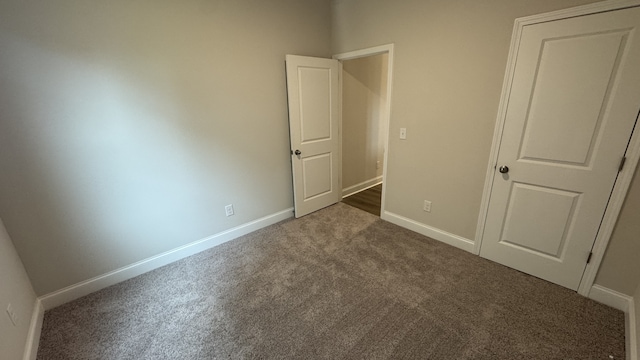 unfurnished bedroom featuring dark carpet