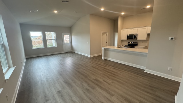 unfurnished living room featuring high vaulted ceiling, dark wood-type flooring, and sink