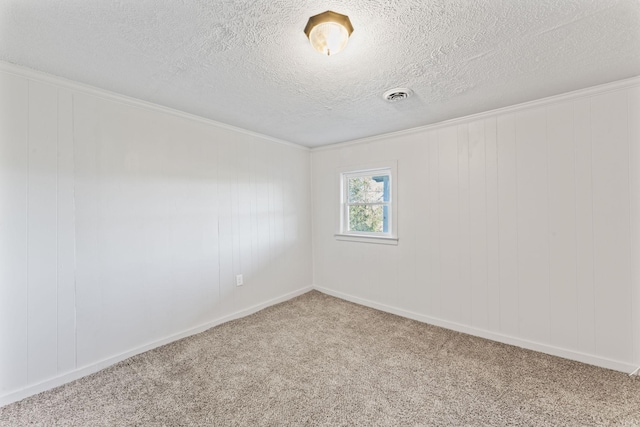 carpeted spare room with visible vents, baseboards, and a textured ceiling