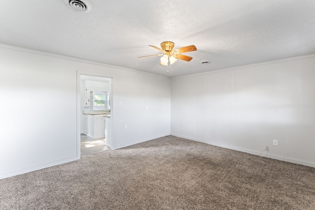 spare room with a textured ceiling, carpet, crown molding, and ceiling fan