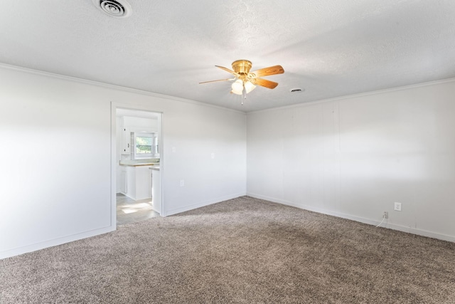 unfurnished room featuring visible vents, ceiling fan, ornamental molding, carpet flooring, and a textured ceiling