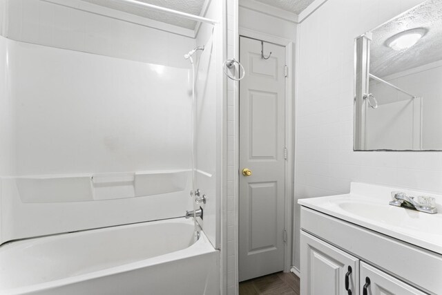 bathroom featuring  shower combination, a textured ceiling, and vanity