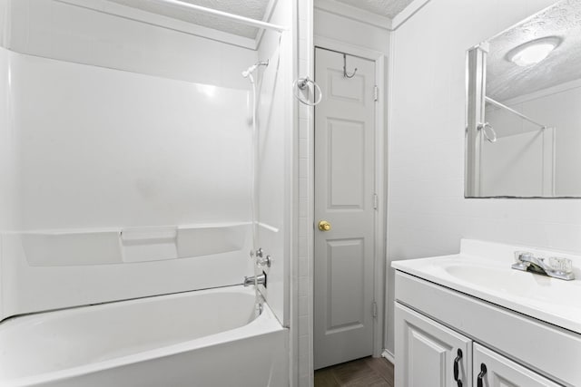 bathroom featuring a textured ceiling, shower / washtub combination, and vanity