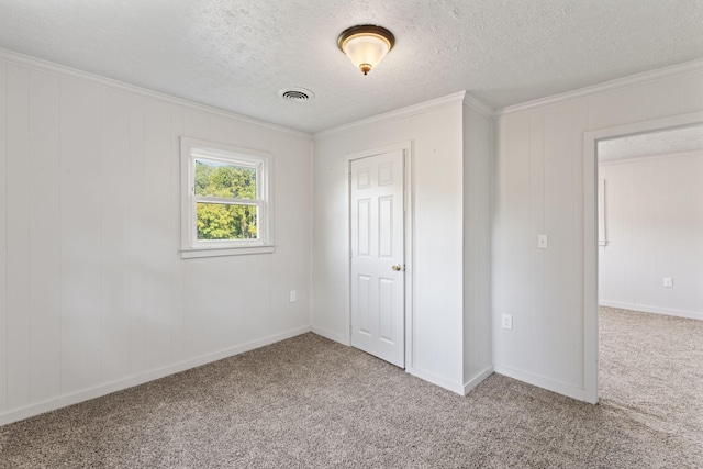 unfurnished bedroom featuring visible vents, a textured ceiling, carpet floors, crown molding, and baseboards