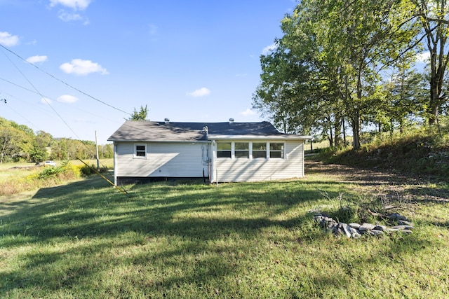 rear view of house featuring a yard