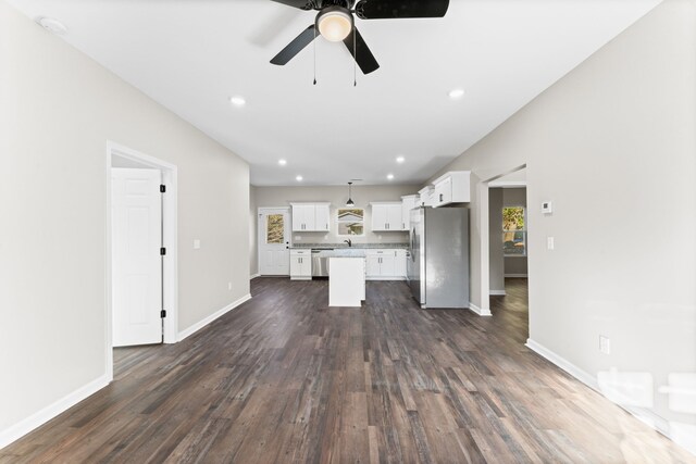 unfurnished living room featuring ceiling fan and dark hardwood / wood-style flooring