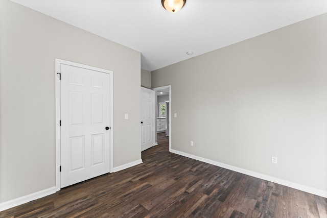 unfurnished bedroom featuring a closet and dark hardwood / wood-style floors