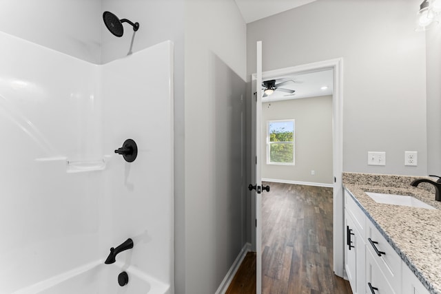 bathroom with ceiling fan, bathing tub / shower combination, hardwood / wood-style flooring, and vanity