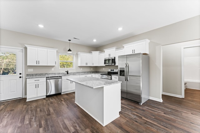 kitchen with pendant lighting, stainless steel appliances, white cabinets, and dark hardwood / wood-style flooring