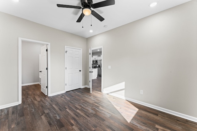 unfurnished bedroom featuring ceiling fan and dark hardwood / wood-style flooring