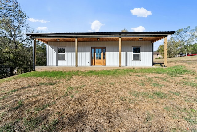 rear view of property featuring a lawn and french doors