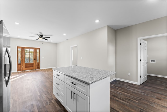 kitchen featuring light stone counters, dark hardwood / wood-style floors, stainless steel fridge with ice dispenser, white cabinetry, and ceiling fan