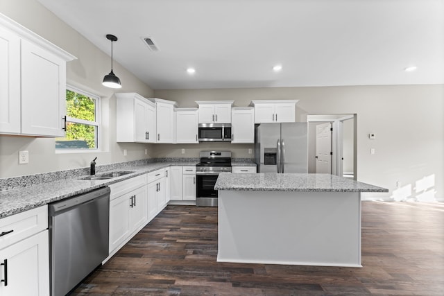 kitchen with appliances with stainless steel finishes, white cabinetry, sink, and dark hardwood / wood-style flooring