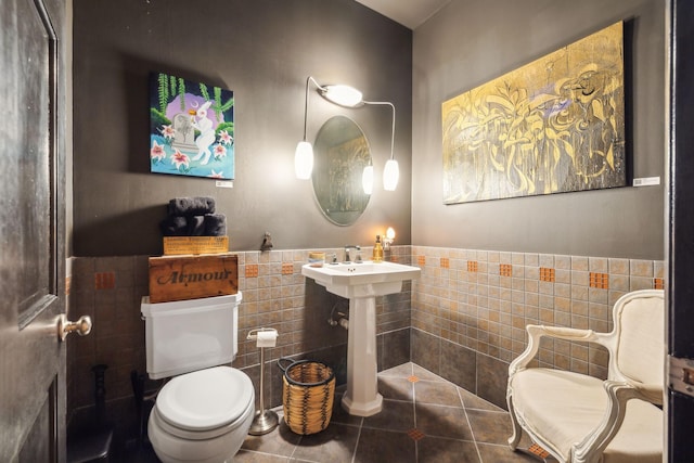 bathroom featuring tile walls, toilet, tile patterned floors, and wainscoting