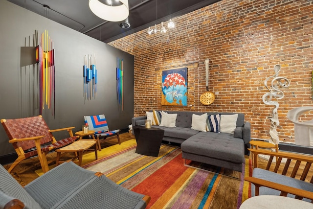 living area featuring wood finished floors and brick wall
