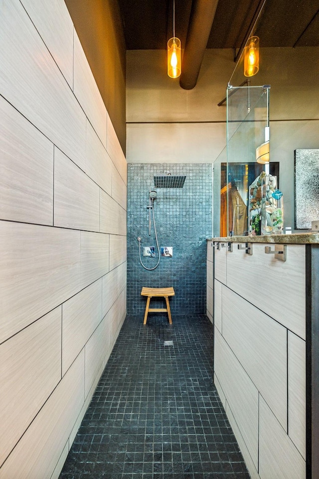 bathroom featuring tile patterned floors, tile walls, vanity, and walk in shower