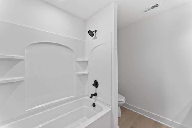 bathroom with shower / bathtub combination, hardwood / wood-style floors, and toilet