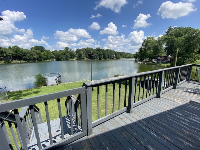 deck with a water view and a yard