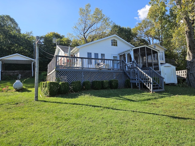 rear view of property featuring a wooden deck, a yard, and a sunroom