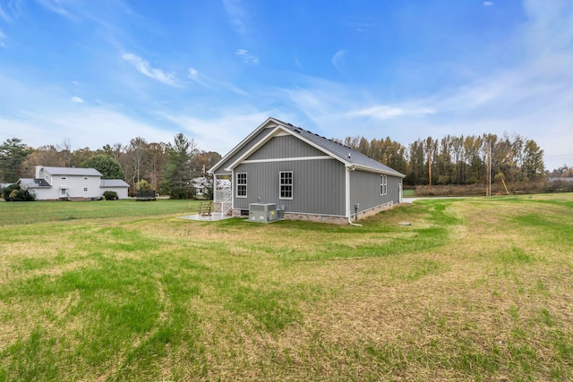 view of property exterior featuring central air condition unit and a lawn