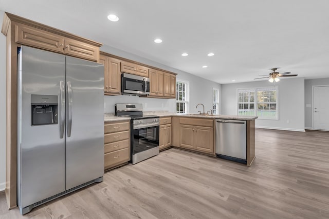 kitchen featuring light wood-type flooring, kitchen peninsula, ceiling fan, and stainless steel appliances