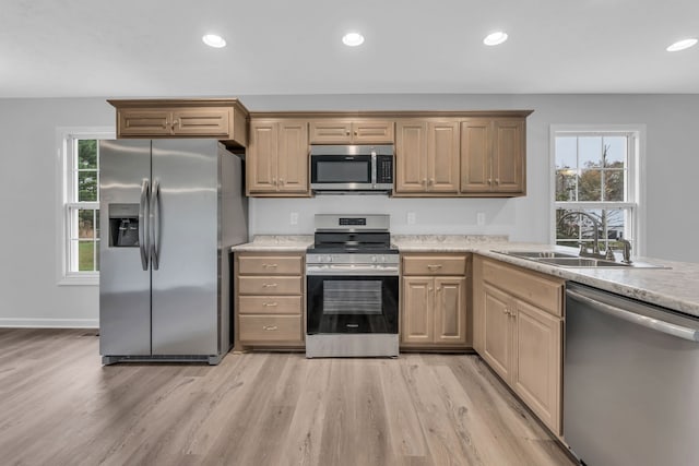 kitchen featuring light brown cabinets, light wood-type flooring, appliances with stainless steel finishes, and sink