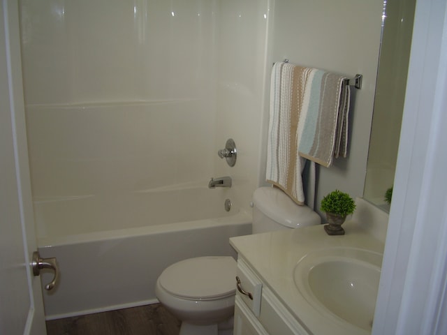 full bathroom featuring washtub / shower combination, wood-type flooring, vanity, and toilet