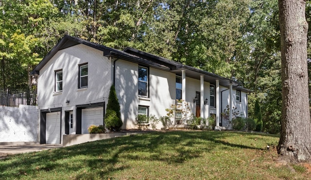 raised ranch featuring a garage and a front yard