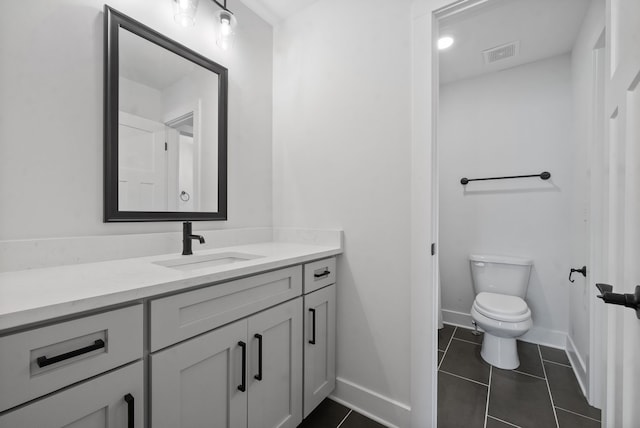 bathroom with tile patterned flooring, vanity, and toilet