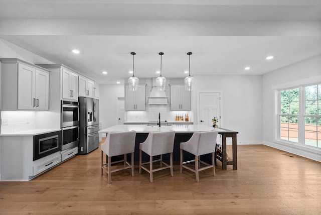 kitchen with decorative backsplash, stainless steel appliances, and light wood-type flooring