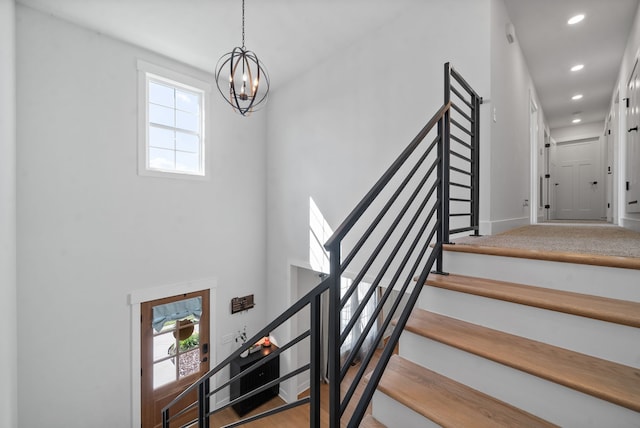 stairway with an inviting chandelier and plenty of natural light