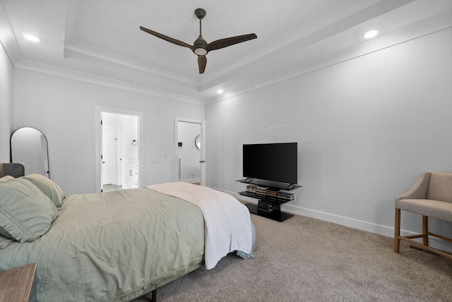 carpeted bedroom featuring a raised ceiling, ornamental molding, ceiling fan, and ensuite bathroom