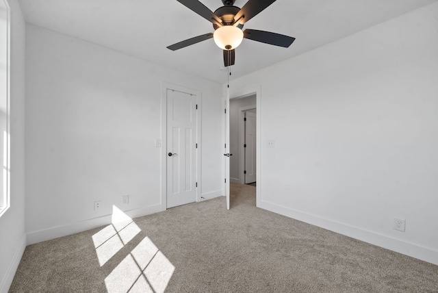 spare room featuring light carpet and ceiling fan