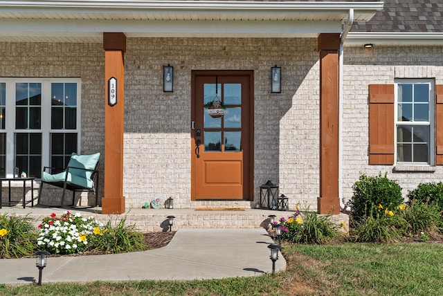 view of exterior entry featuring covered porch