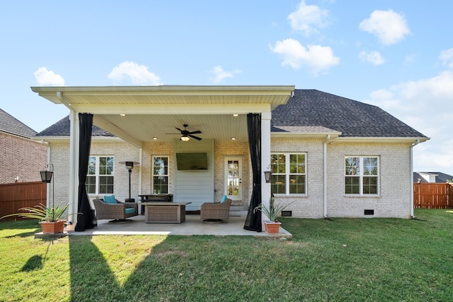 back of property with ceiling fan, a patio area, and a yard