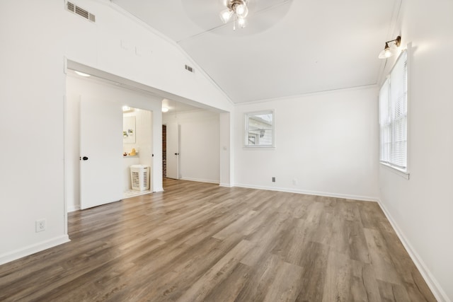 unfurnished living room featuring hardwood / wood-style floors, vaulted ceiling, crown molding, and ceiling fan