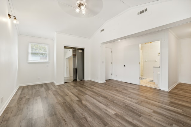 unfurnished bedroom featuring ensuite bathroom, hardwood / wood-style floors, ceiling fan, lofted ceiling, and crown molding