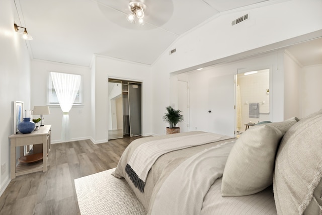 bedroom with a closet, light hardwood / wood-style floors, ceiling fan, lofted ceiling, and ornamental molding