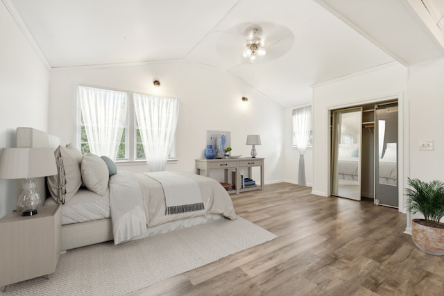 bedroom featuring a closet, wood-type flooring, vaulted ceiling, and ceiling fan