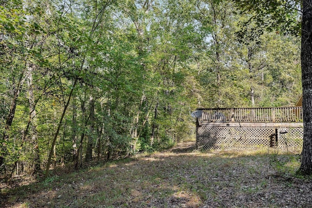 view of gate with a view of trees and a wooden deck