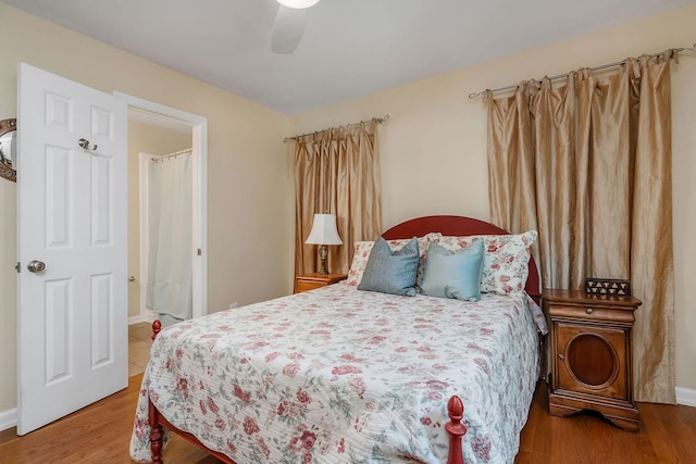 bedroom featuring ceiling fan, baseboards, and wood finished floors