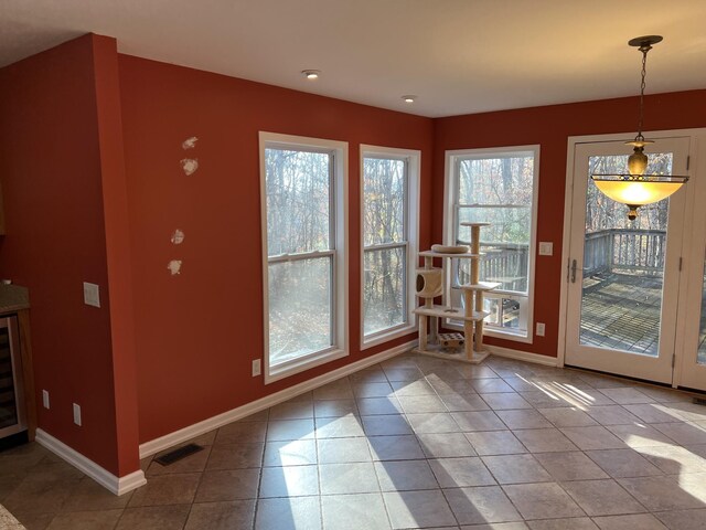 doorway to outside with baseboards, visible vents, and tile patterned floors