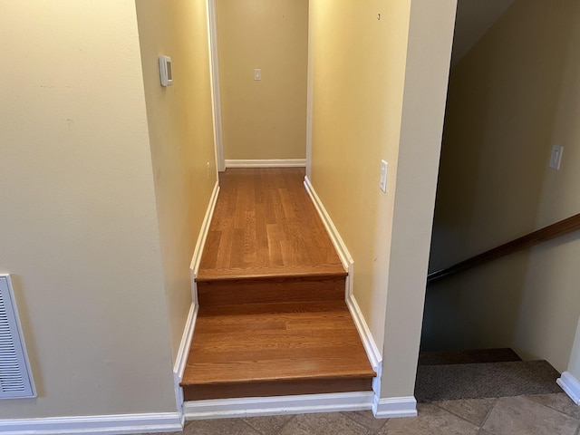 staircase with visible vents and baseboards