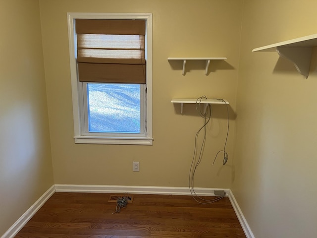 laundry area featuring dark wood finished floors, visible vents, and baseboards